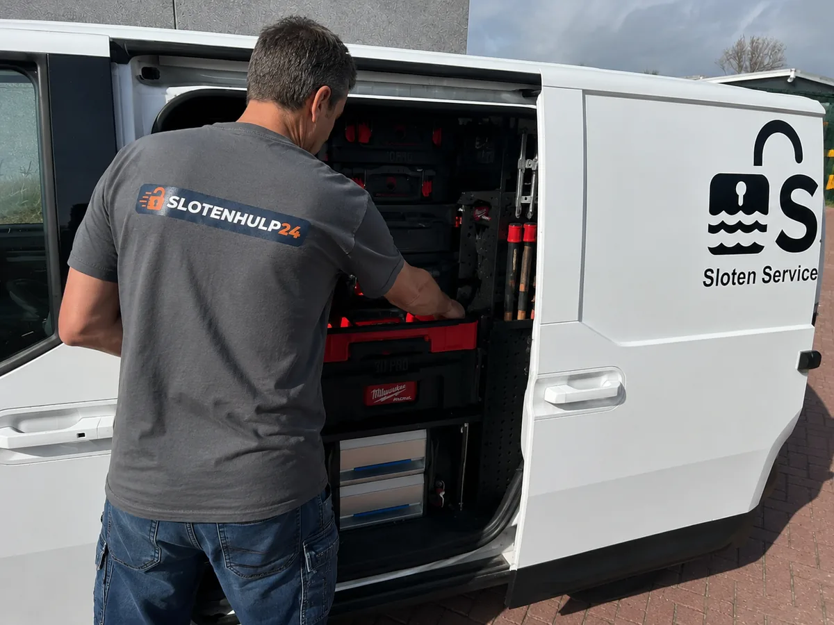 Slotenmaker pakt zijn gereedschap uit de bedrijfsbus voor een klus