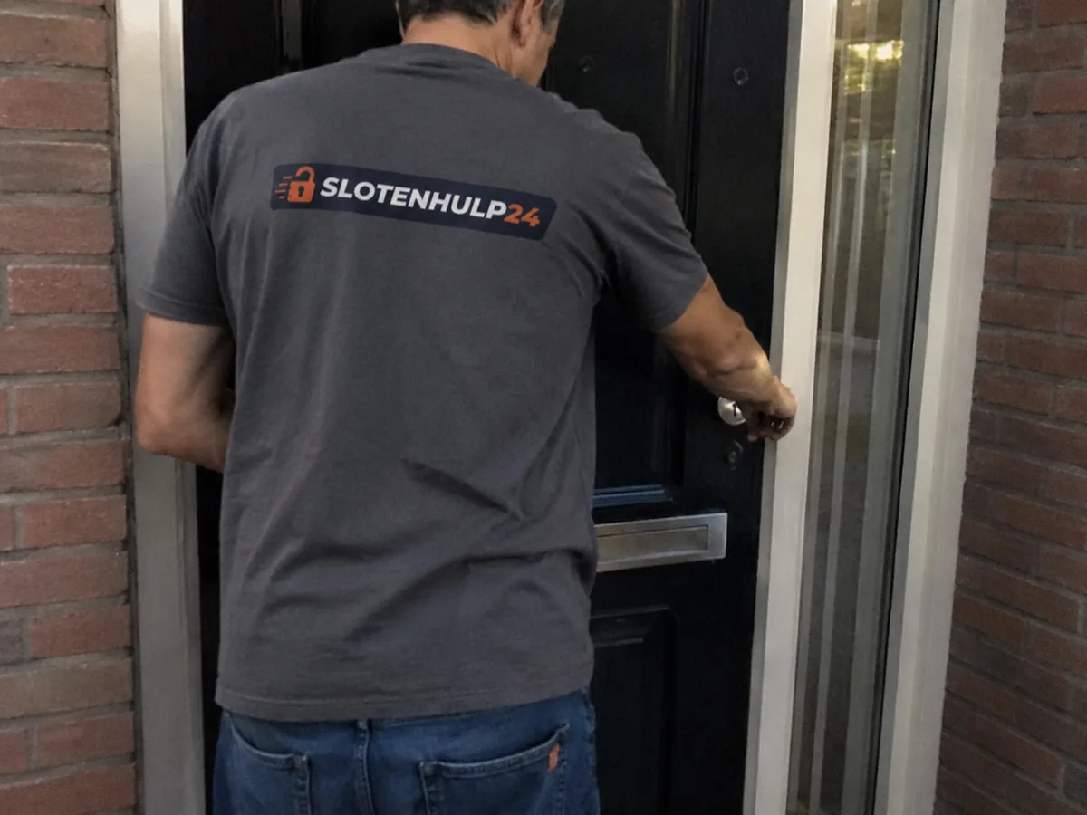 Slotenmaker van Slotenhulp24 opent een voordeur, herkenbaar in bedrijfskleding